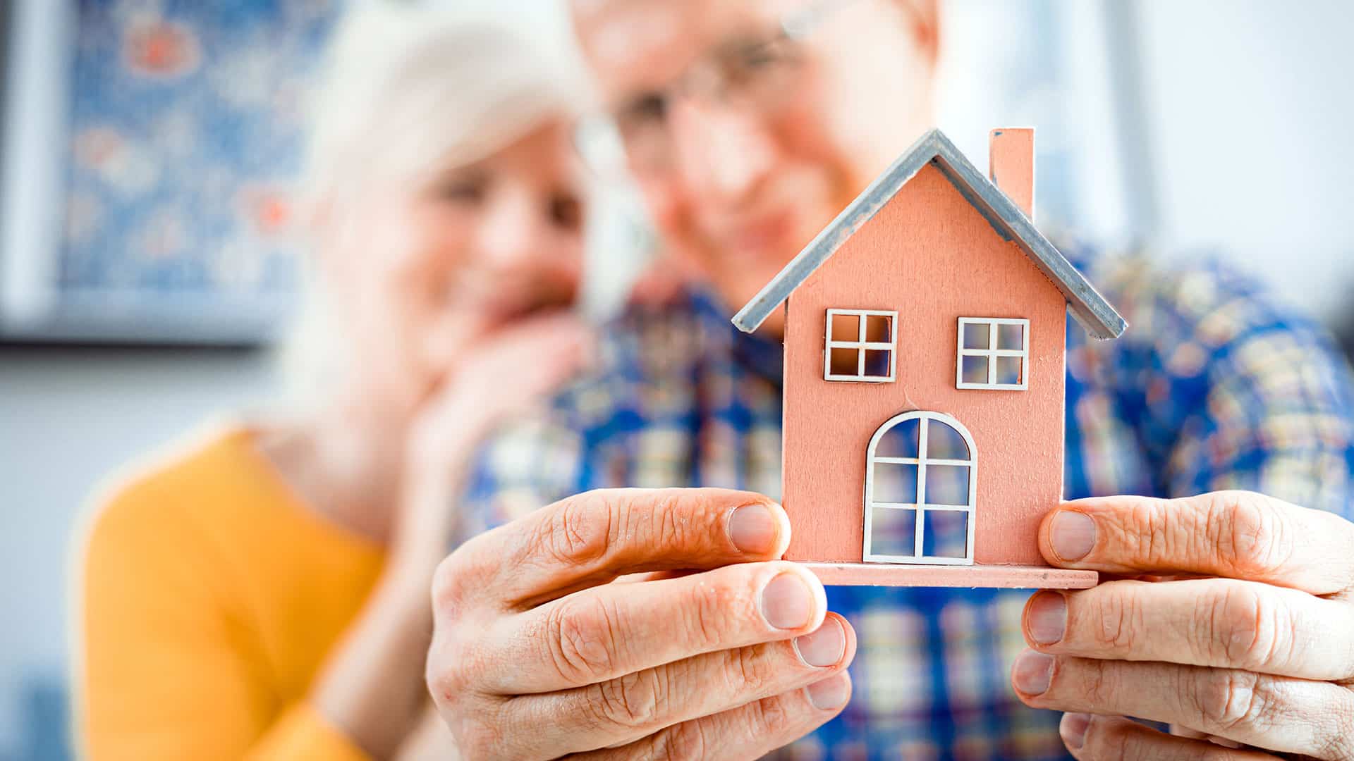 older couple with house model