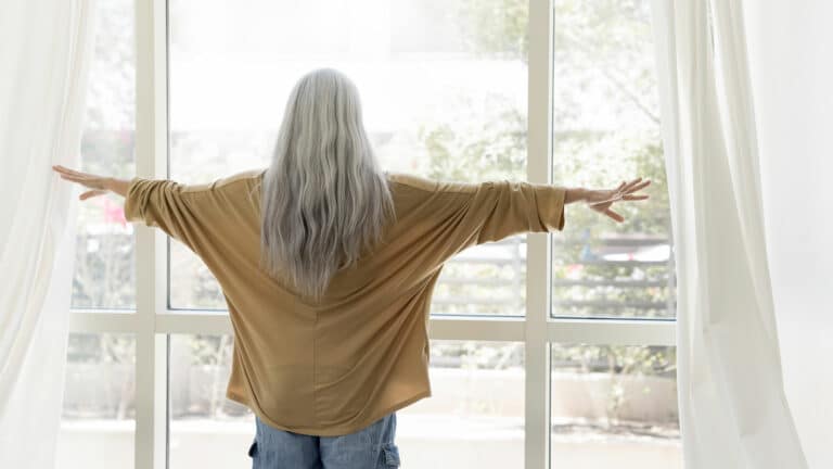 Older woman looking through window